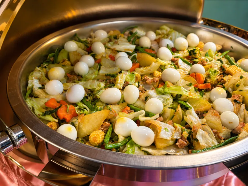 Chop suey with mixed vegetables and quail eggs in a chafing dish