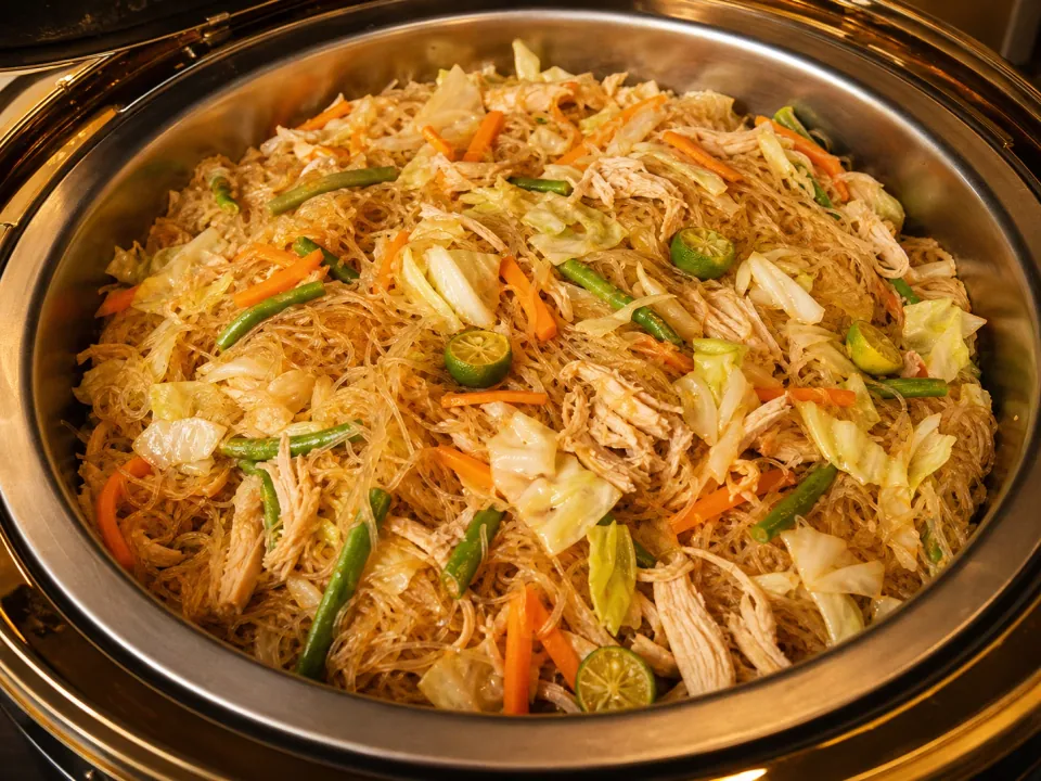 Pancit sotanghon with chicken and vegetables in a chafing dish