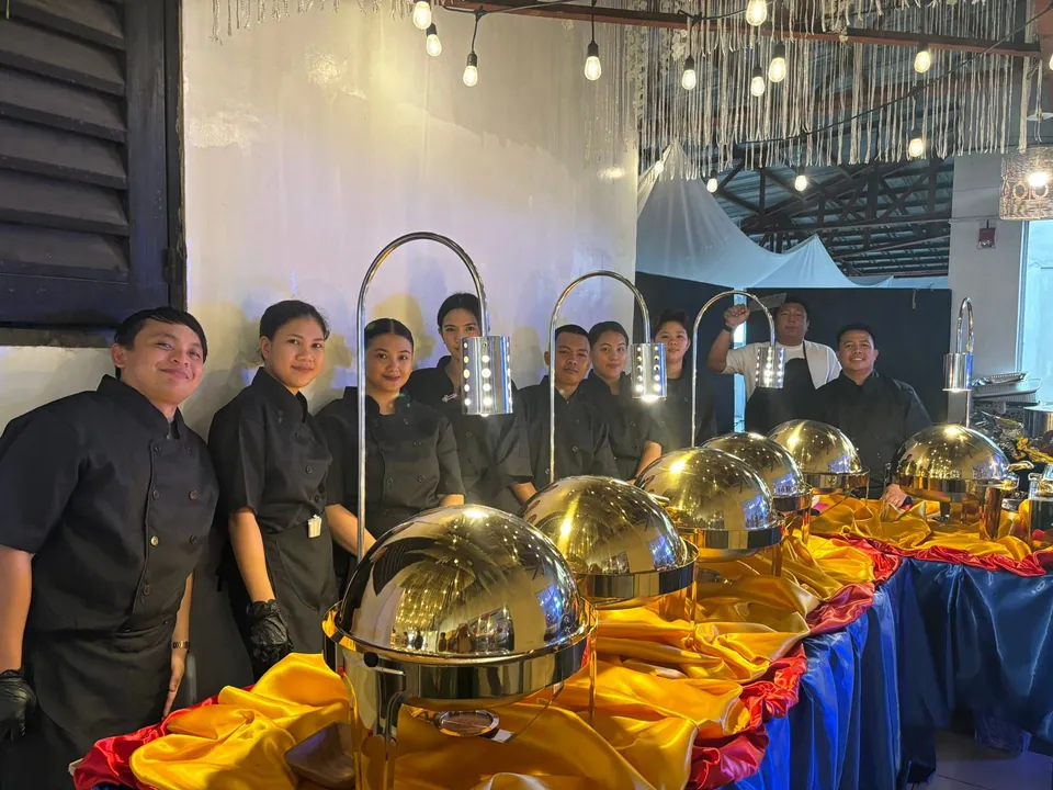 Yhan's Catering Services crew standing behind a catered buffet